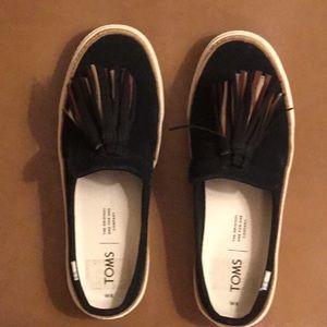 Tom’s Black suede Sunrise tassel slides.